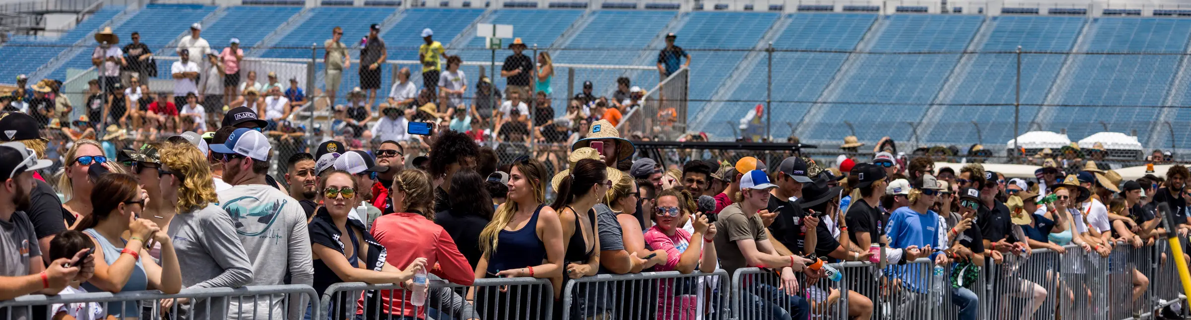 Automotive enthusiasts lining the rail at a live event