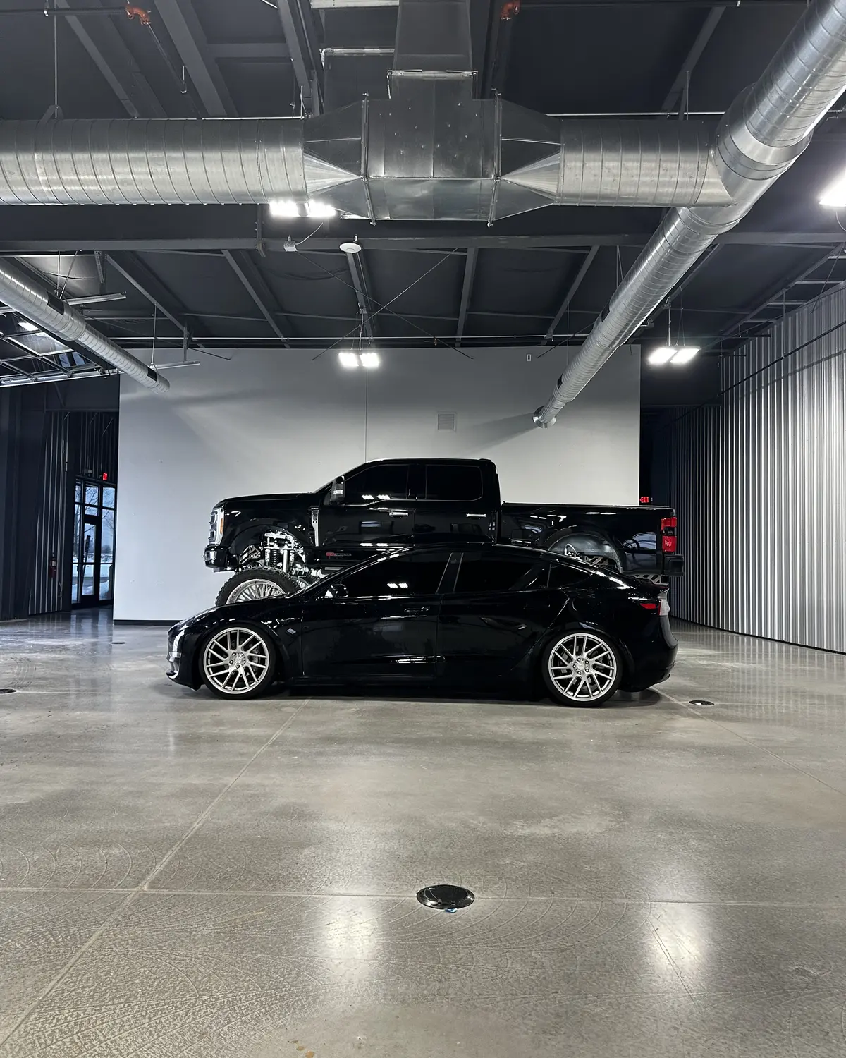 Black performance car and custom truck in a private automotive space